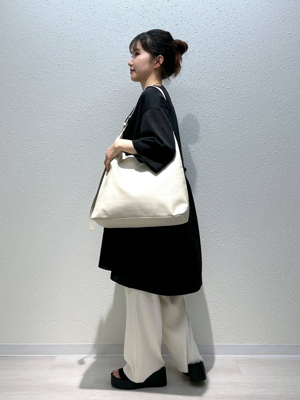 ブラック系のサンダル、ホワイト系のその他パンツ、ブラック系のTシャツ/カットソーを着用したレディースの春コーディネートの7枚目の写真