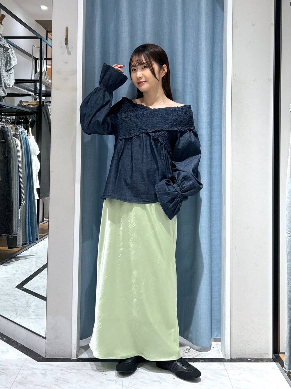 ブルー系のシャツ/ブラウス、ブラック系のスニーカー、グリーン系のスカートを着用したレディースの春コーディネートの2枚目の写真