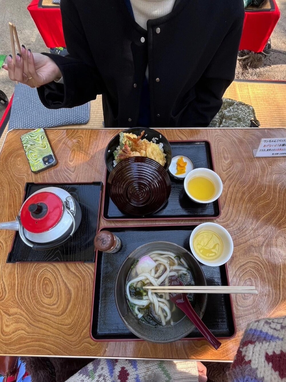 ブラック系のノーカラージャケット、ホワイト系のニット/セーター、ブラック系のスラックスを着用したレディースの冬コーディネートの2枚目の写真