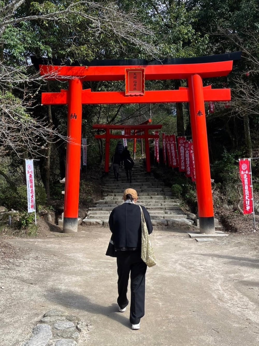 ブラック系のノーカラージャケット、ホワイト系のニット/セーター、ブラック系のスラックスを着用したレディースの冬コーディネートの3枚目の写真