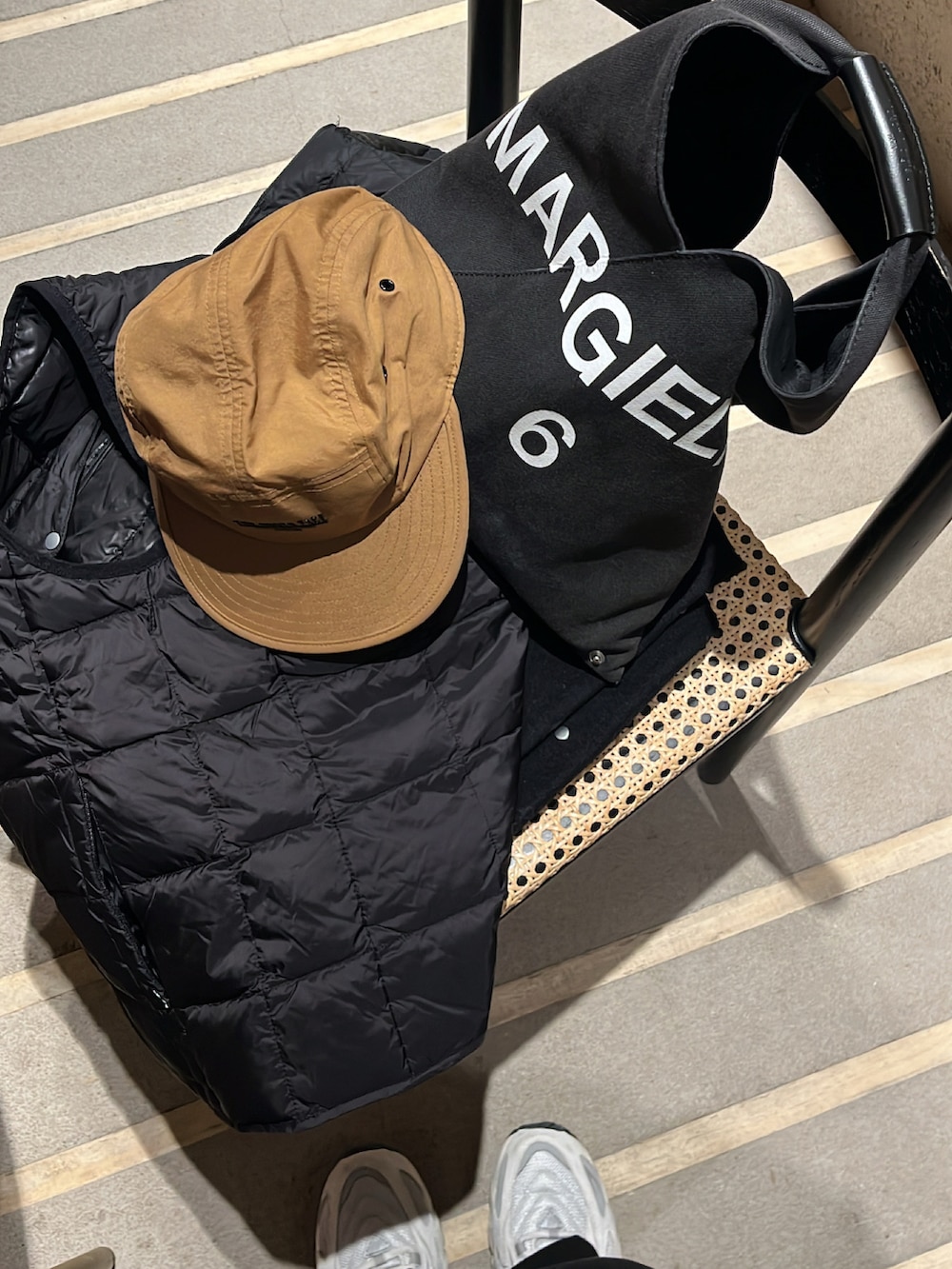 ブラック系のノーカラージャケット、ホワイト系のニット/セーター、ブラック系のスラックスを着用したレディースの冬コーディネートの4枚目の写真