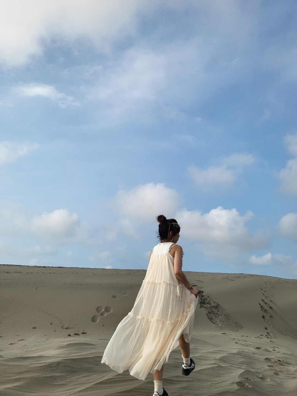 ベージュ系のワンピースを着用したレディースの秋コーディネートの2枚目の写真