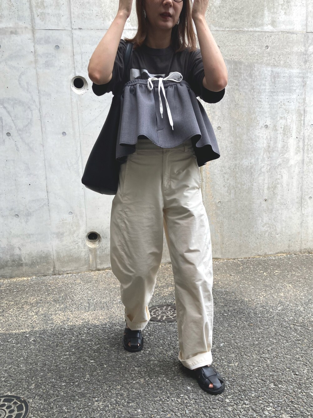 ブラック系のTシャツ/カットソー、グレー系のスカート、ホワイト系のパンツを着用したレディースの秋コーディネートの2枚目の写真