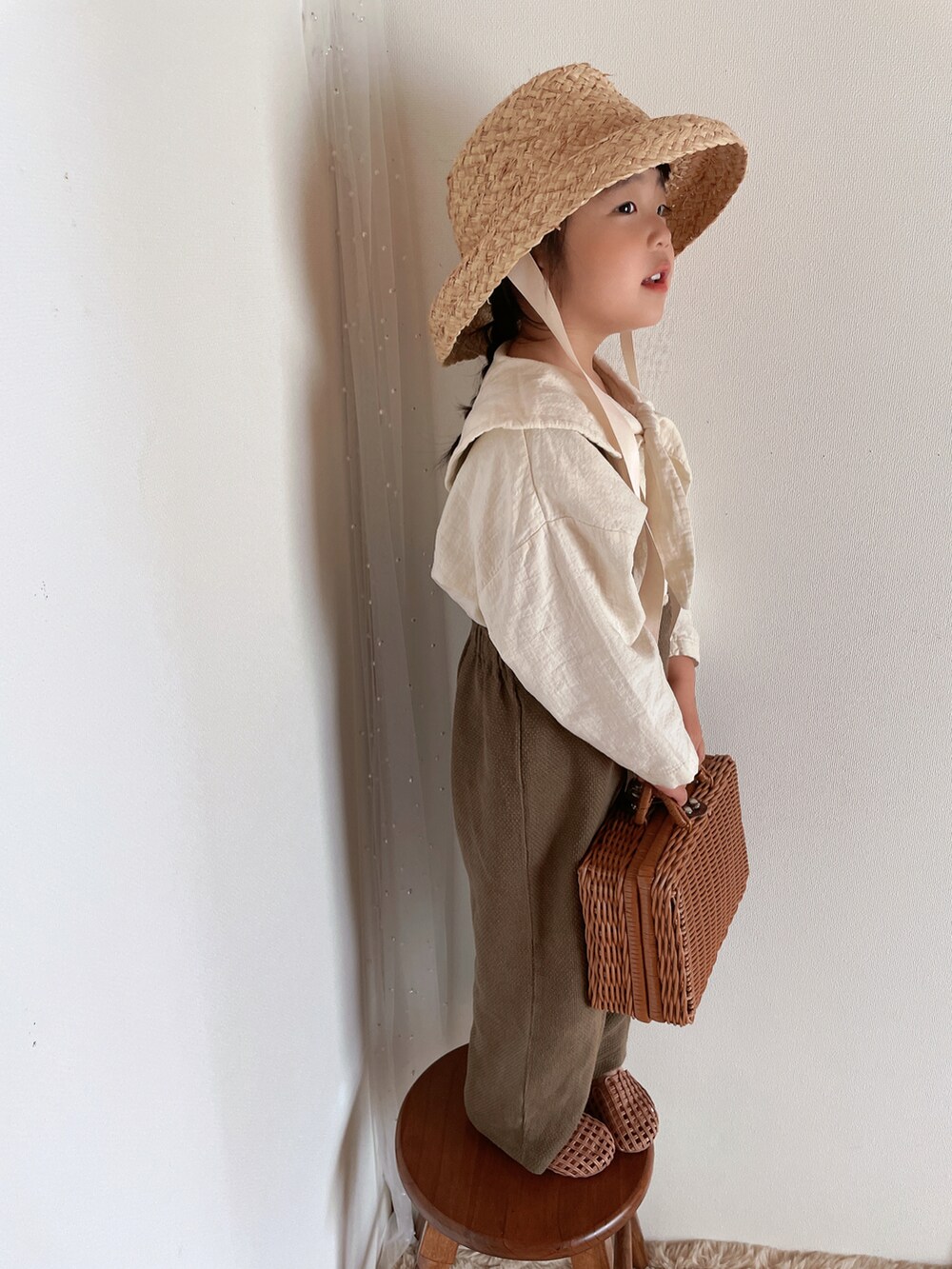ブラウン系のサンダル、ベージュ系の帽子を着用したキッズの春コーディネートの4枚目の写真