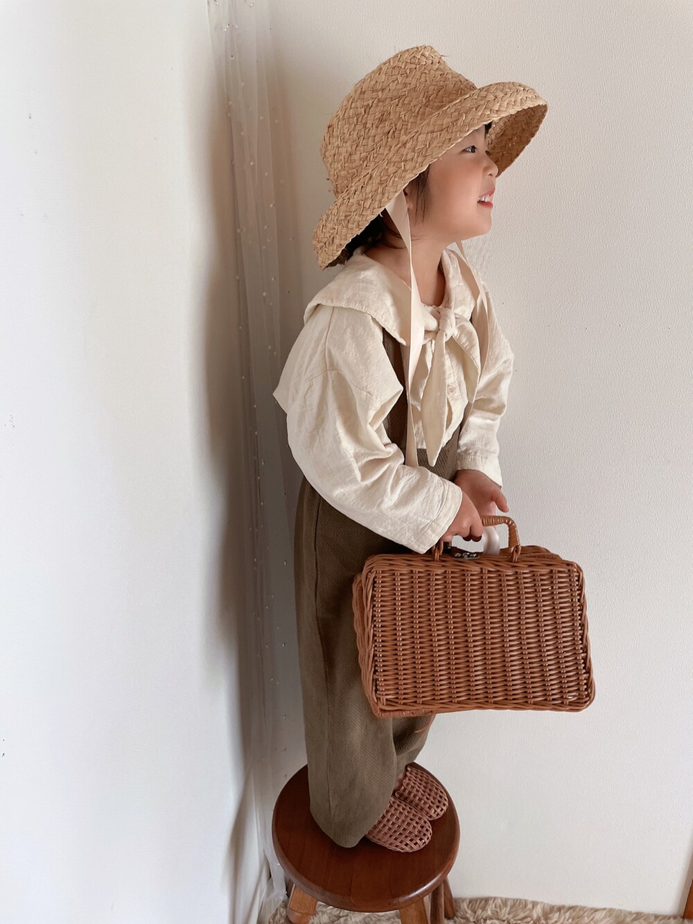 ブラウン系のサンダル、ベージュ系の帽子を着用したキッズの春コーディネートの5枚目の写真