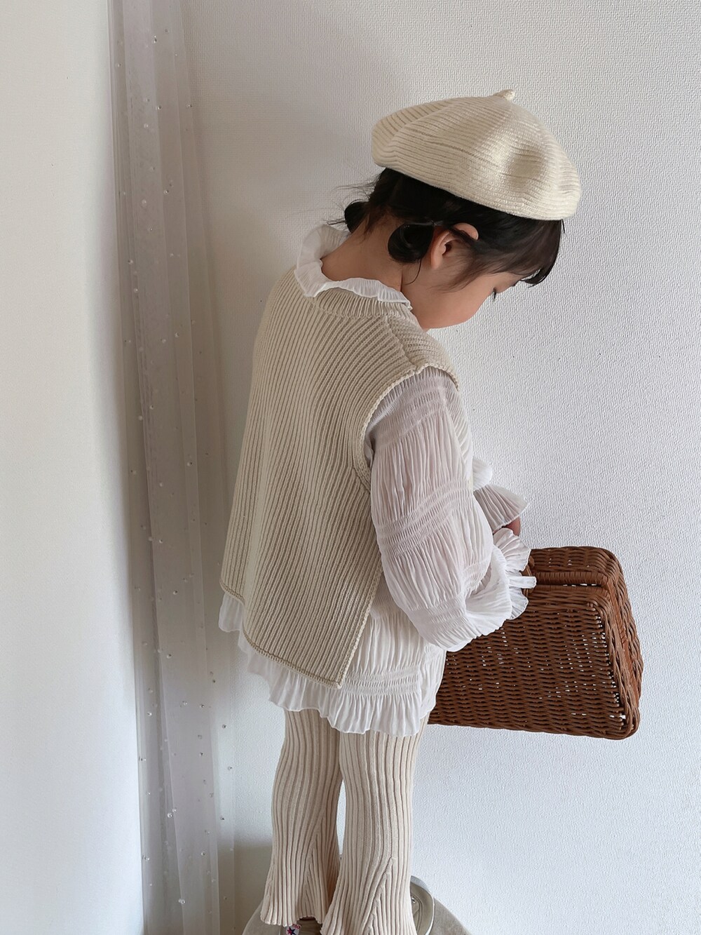 ホワイト系のベスト、ベージュ系のシューズ、ホワイト系のハンチング/ベレー帽を着用したキッズの春コーディネートの5枚目の写真