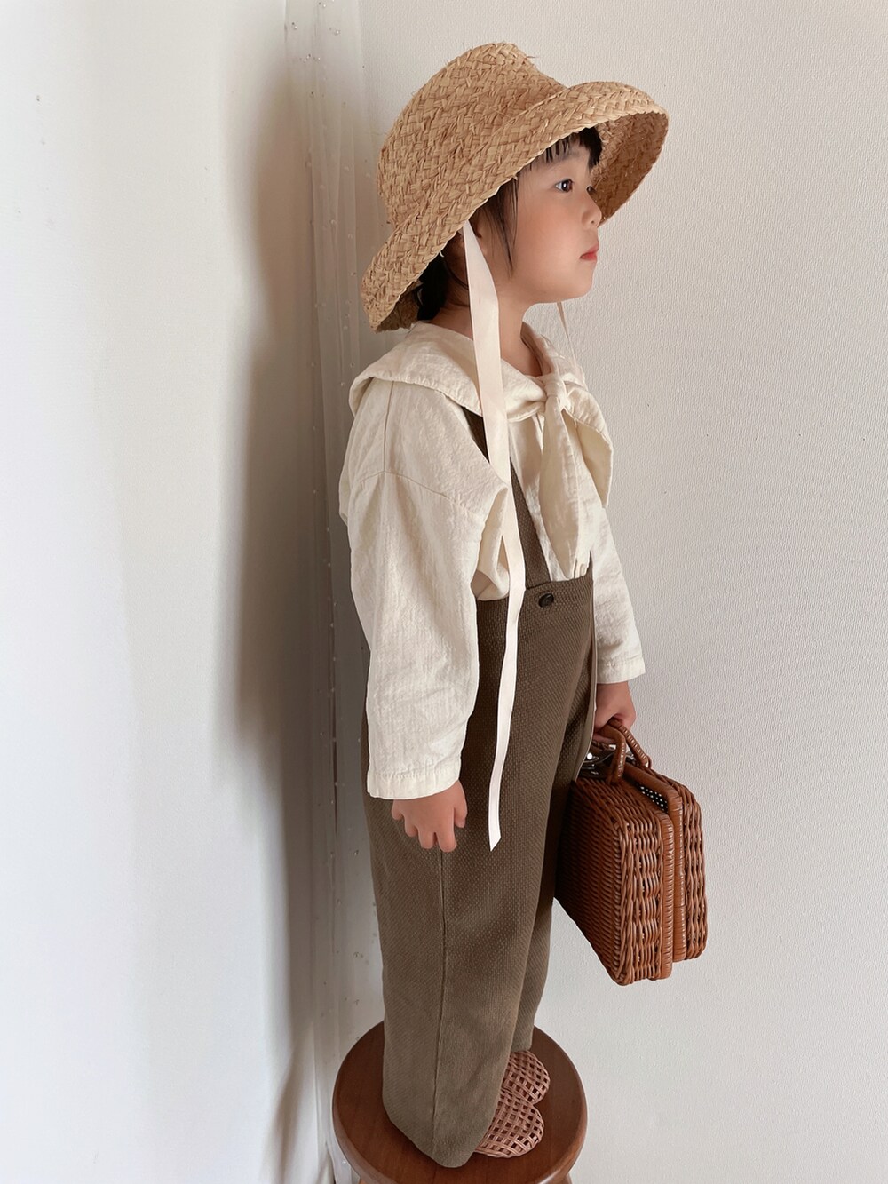 ブラウン系のサンダル、ベージュ系の帽子を着用したキッズの春コーディネートの3枚目の写真