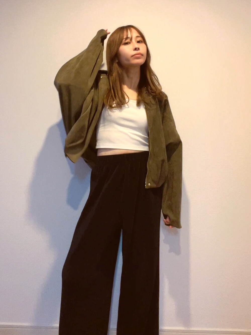 グリーン系のジャケット/アウター、ホワイト系のキャミソールを着用したレディースの秋コーディネートの3枚目の写真