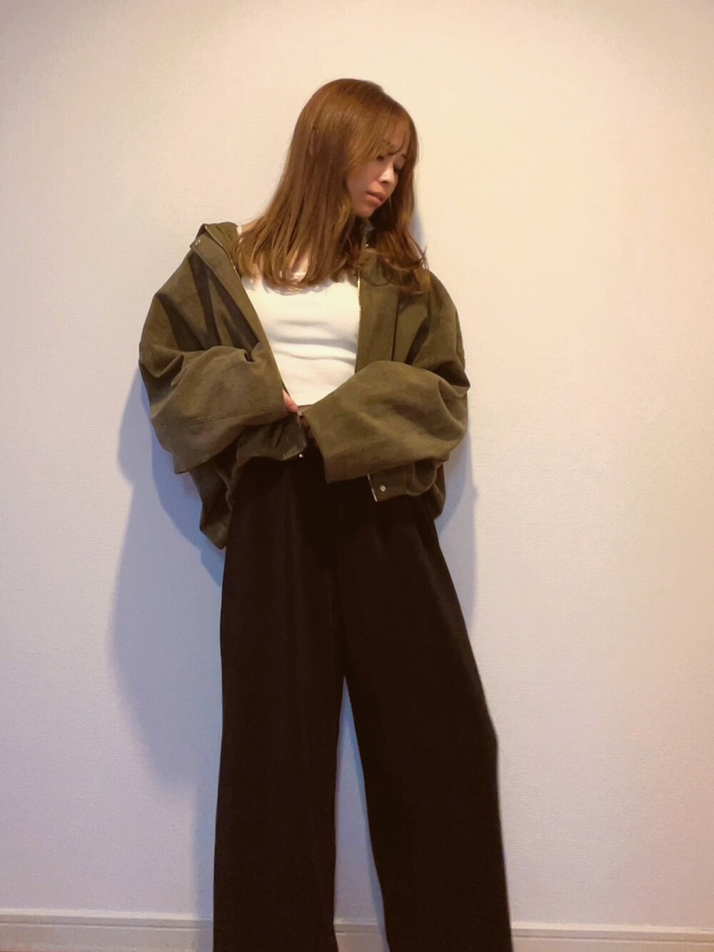 グリーン系のジャケット/アウター、ホワイト系のキャミソールを着用したレディースの秋コーディネートの2枚目の写真