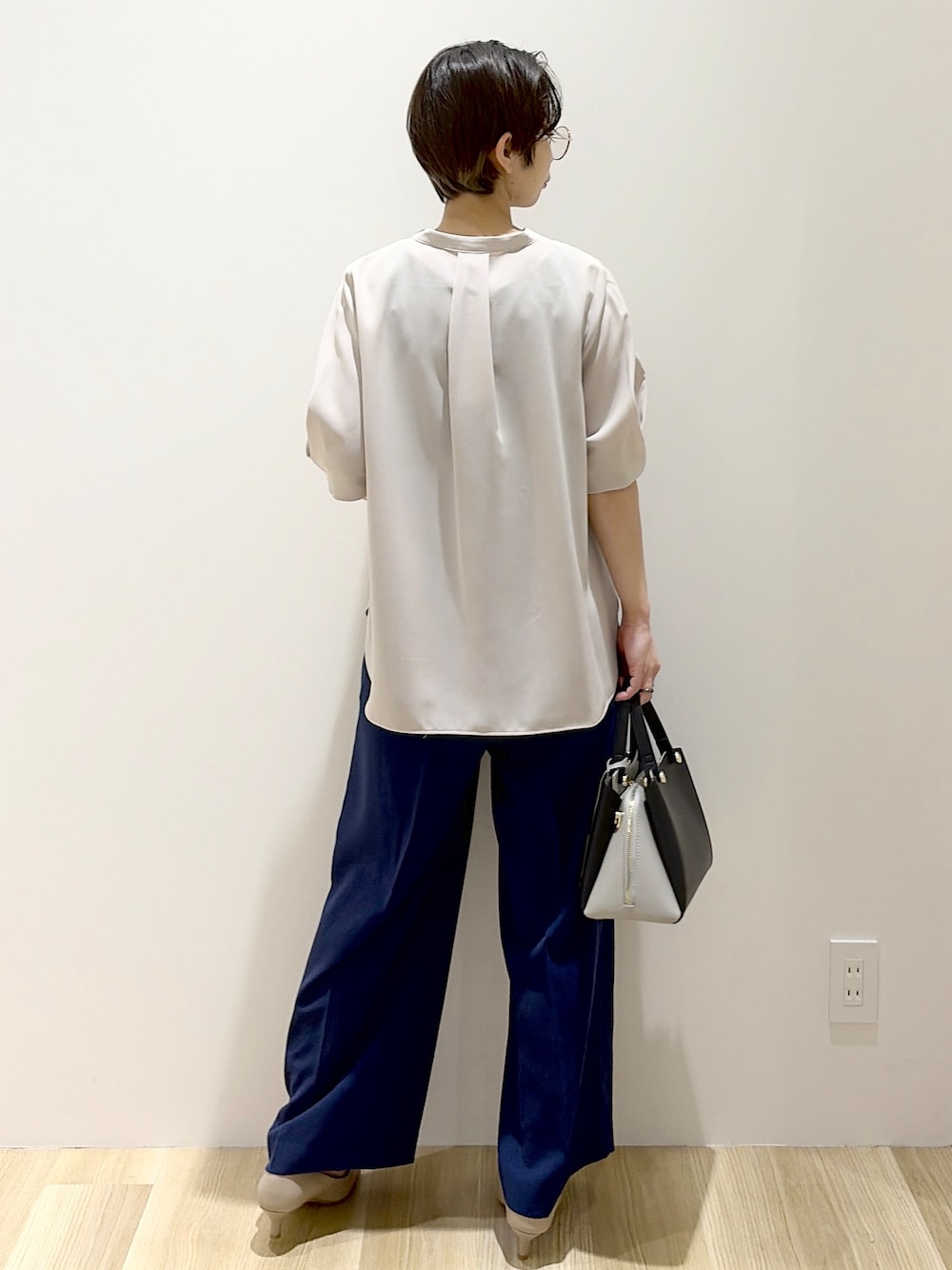 ブラック系のショルダーバッグ、ベージュ系のパンプス、ベージュ系のシャツ/ブラウスを着用したレディースの春コーディネートの4枚目の写真