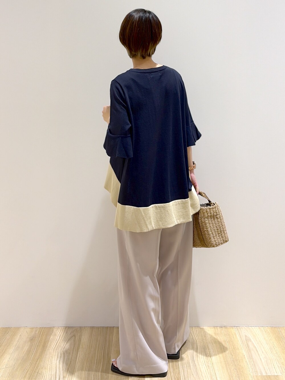 ブルー系のニット/セーター、ベージュ系のその他パンツ、ブラウン系のトートバッグを着用したレディースの夏コーディネートの3枚目の写真