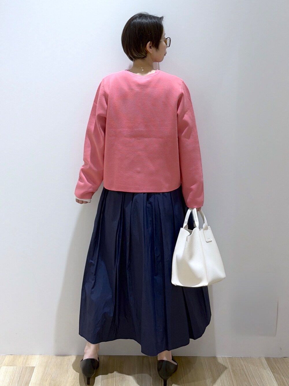ホワイト系のショルダーバッグ、ブラック系のパンプス、ブルー系のスカートを着用したレディースの春コーディネートの3枚目の写真