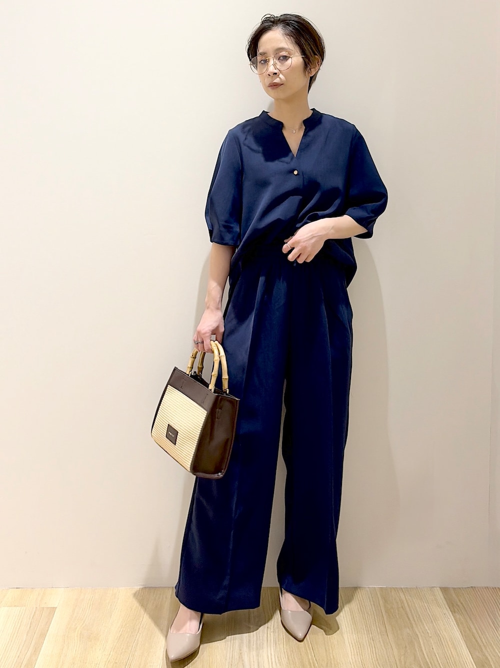 ブラック系のショルダーバッグ、ベージュ系のパンプス、ベージュ系のシャツ/ブラウスを着用したレディースの春コーディネートの7枚目の写真