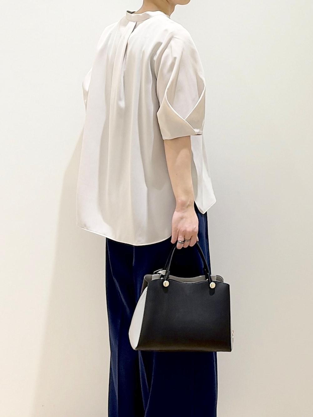 ブラック系のショルダーバッグ、ベージュ系のパンプス、ベージュ系のシャツ/ブラウスを着用したレディースの春コーディネートの6枚目の写真