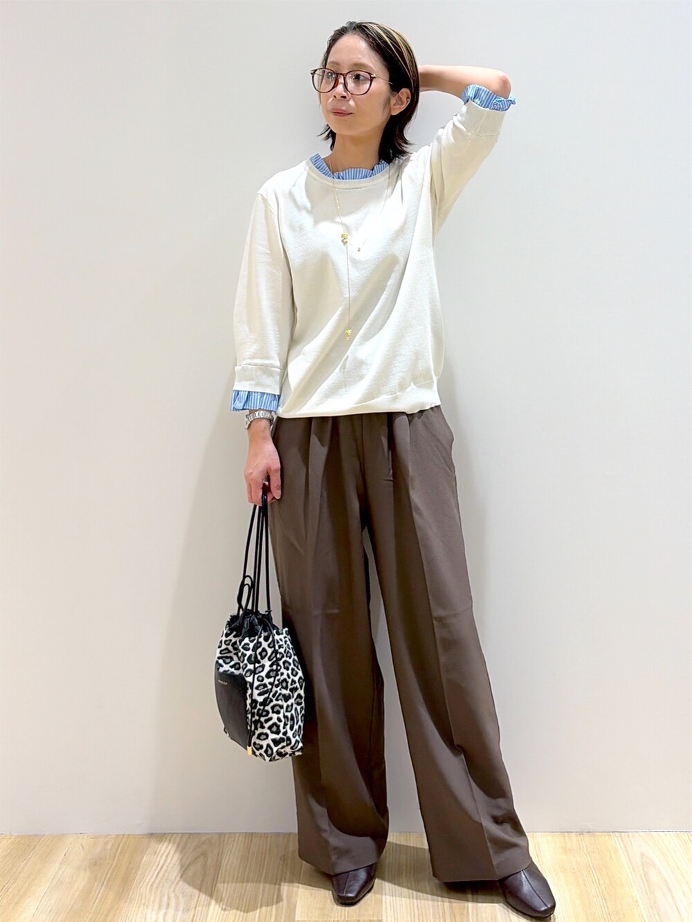 レッド系のニット/セーター、ブラウン系のその他パンツ、ブラック系のショルダーバッグを着用したレディースの秋コーディネートの6枚目の写真