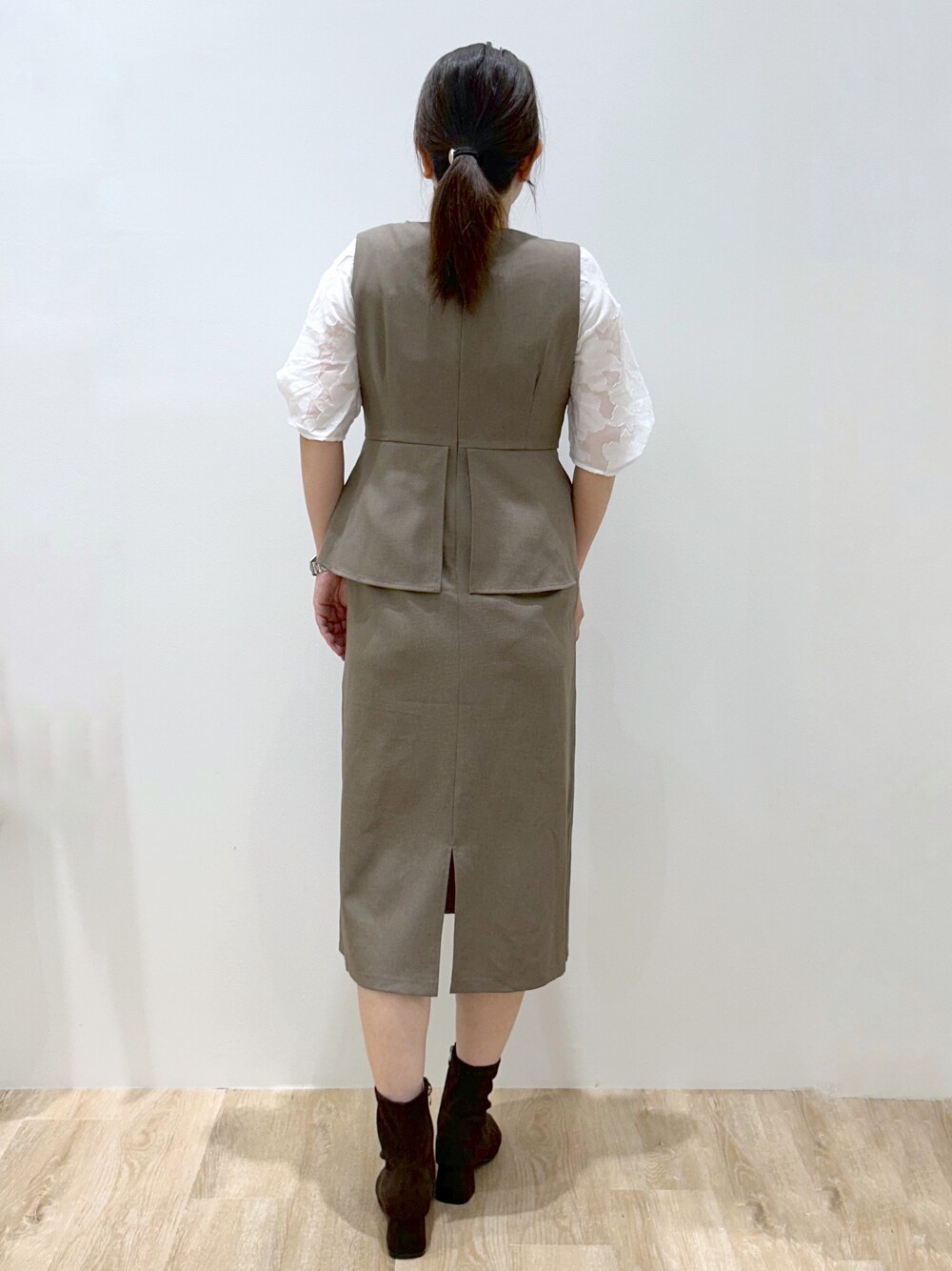 ブラウン系のワンピース、ホワイト系のTシャツ/カットソー、ブラウン系のブーツを着用したレディースの秋コーディネートの3枚目の写真