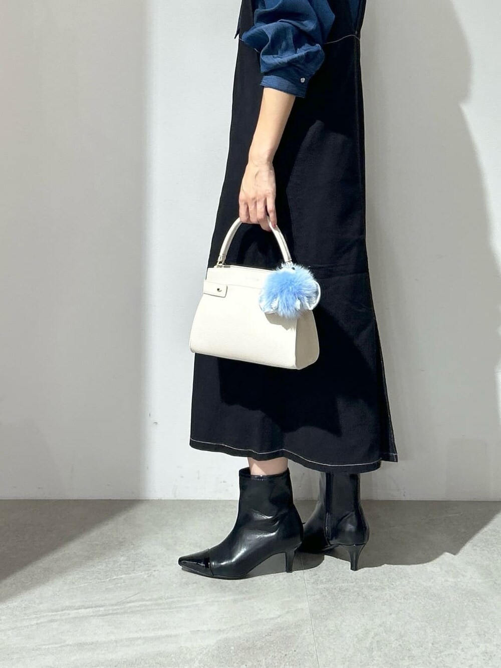 ブルー系のシャツ/ブラウス、ブラック系のワンピース、ホワイト系のショルダーバッグを着用したレディースの秋コーディネートの6枚目の写真