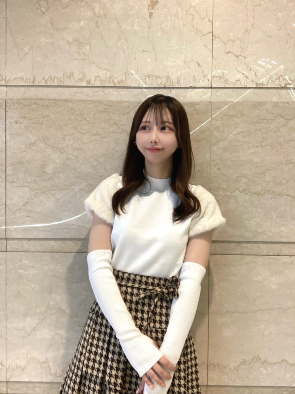 ホワイト系のニット/セーター、ベージュ系のスカート、ブラウン系のブーツを着用したレディースの秋コーディネートの4枚目の写真