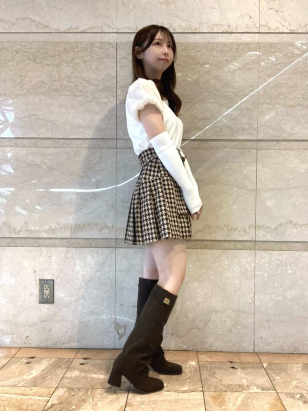 ホワイト系のニット/セーター、ベージュ系のスカート、ブラウン系のブーツを着用したレディースの秋コーディネートの2枚目の写真