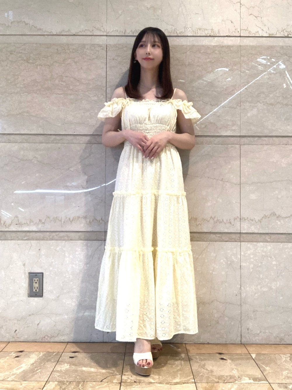 イエロー系のワンピース、ホワイト系のサンダルを着用したレディースの夏コーディネートの2枚目の写真
