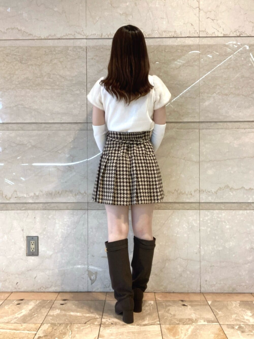 ホワイト系のニット/セーター、ベージュ系のスカート、ブラウン系のブーツを着用したレディースの秋コーディネートの3枚目の写真