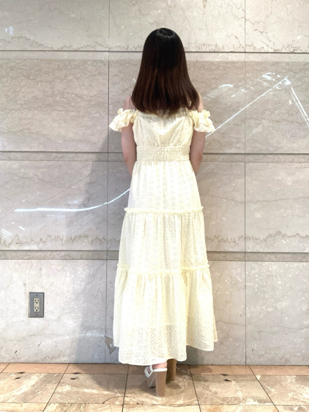 イエロー系のワンピース、ホワイト系のサンダルを着用したレディースの夏コーディネートの4枚目の写真