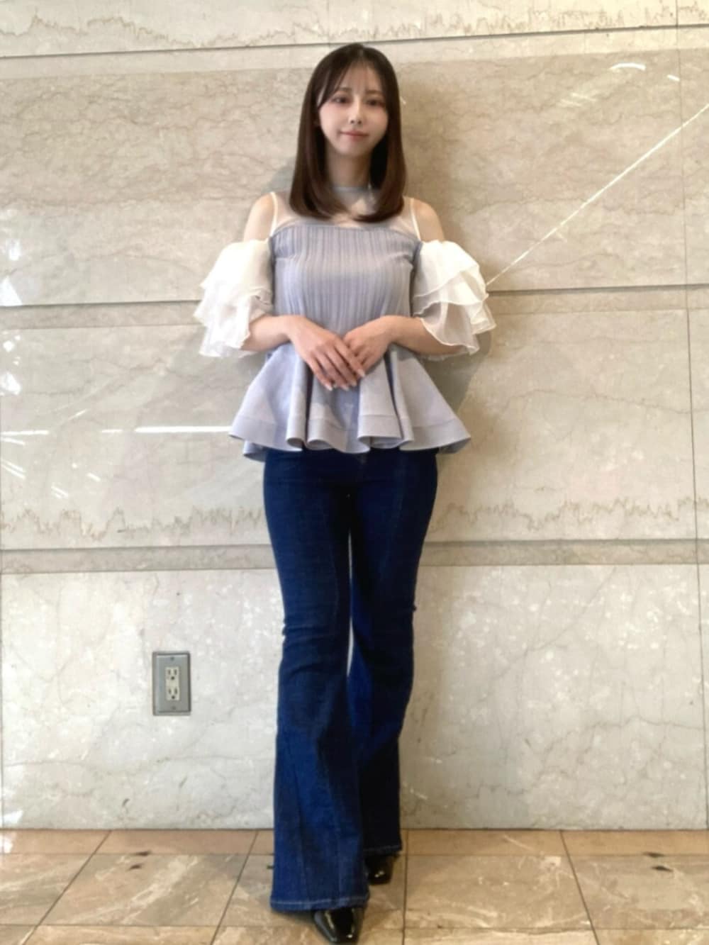 パープル系のその他トップス、ブルー系のデニムパンツ、ブラック系のサンダルを着用したレディースの春コーディネートの2枚目の写真