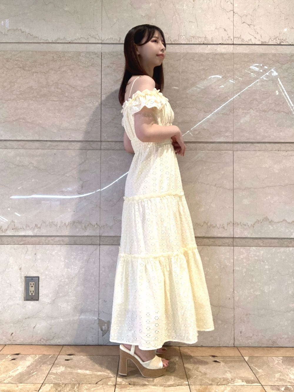 イエロー系のワンピース、ホワイト系のサンダルを着用したレディースの夏コーディネートの3枚目の写真