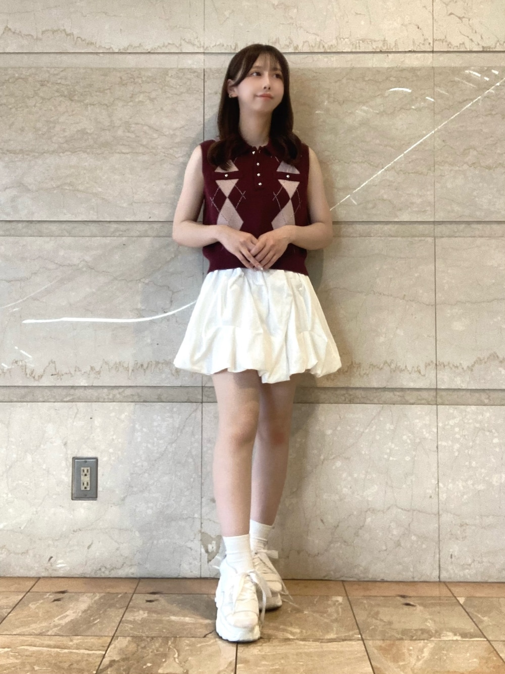 レッド系のニット/セーター、ホワイト系のスカート、ホワイト系のサンダルを着用したレディースの夏コーディネートの2枚目の写真