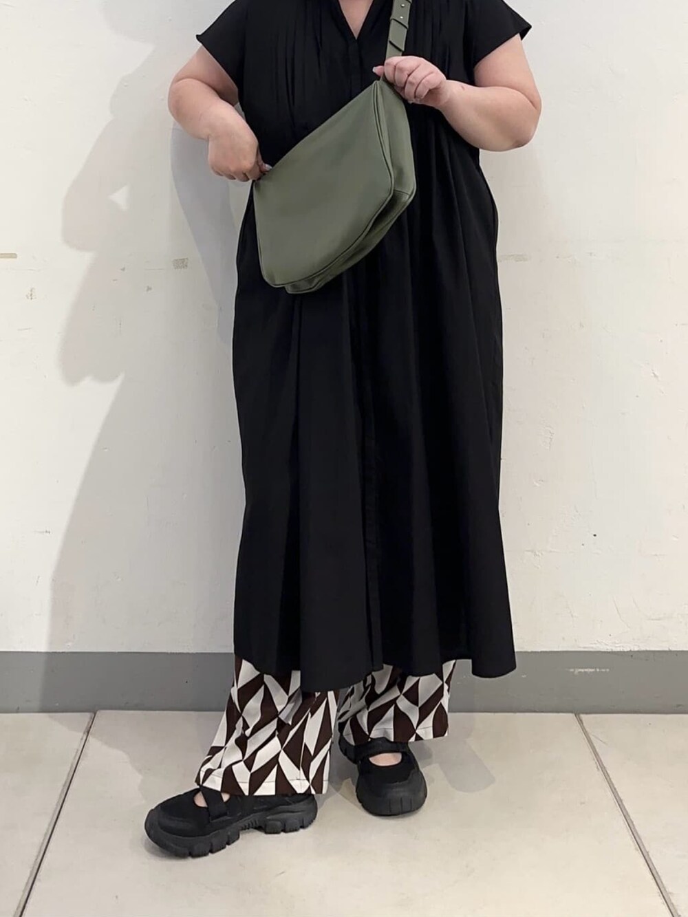 グリーン系のショルダーバッグを着用したレディースの秋コーディネートの4枚目の写真