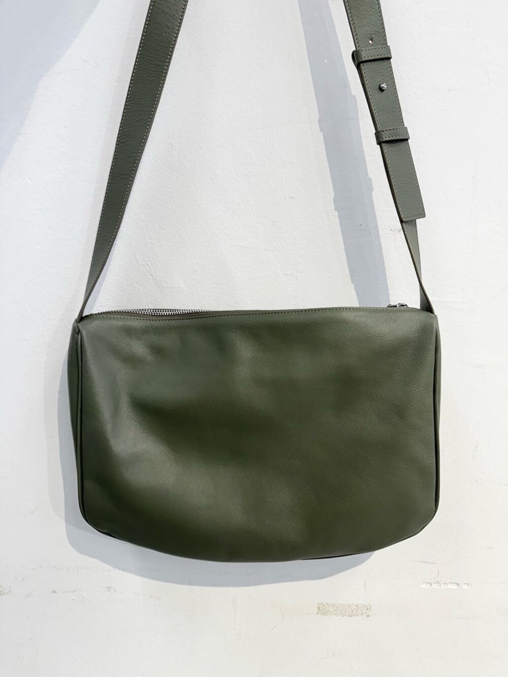 グリーン系のショルダーバッグを着用したレディースの秋コーディネートの3枚目の写真