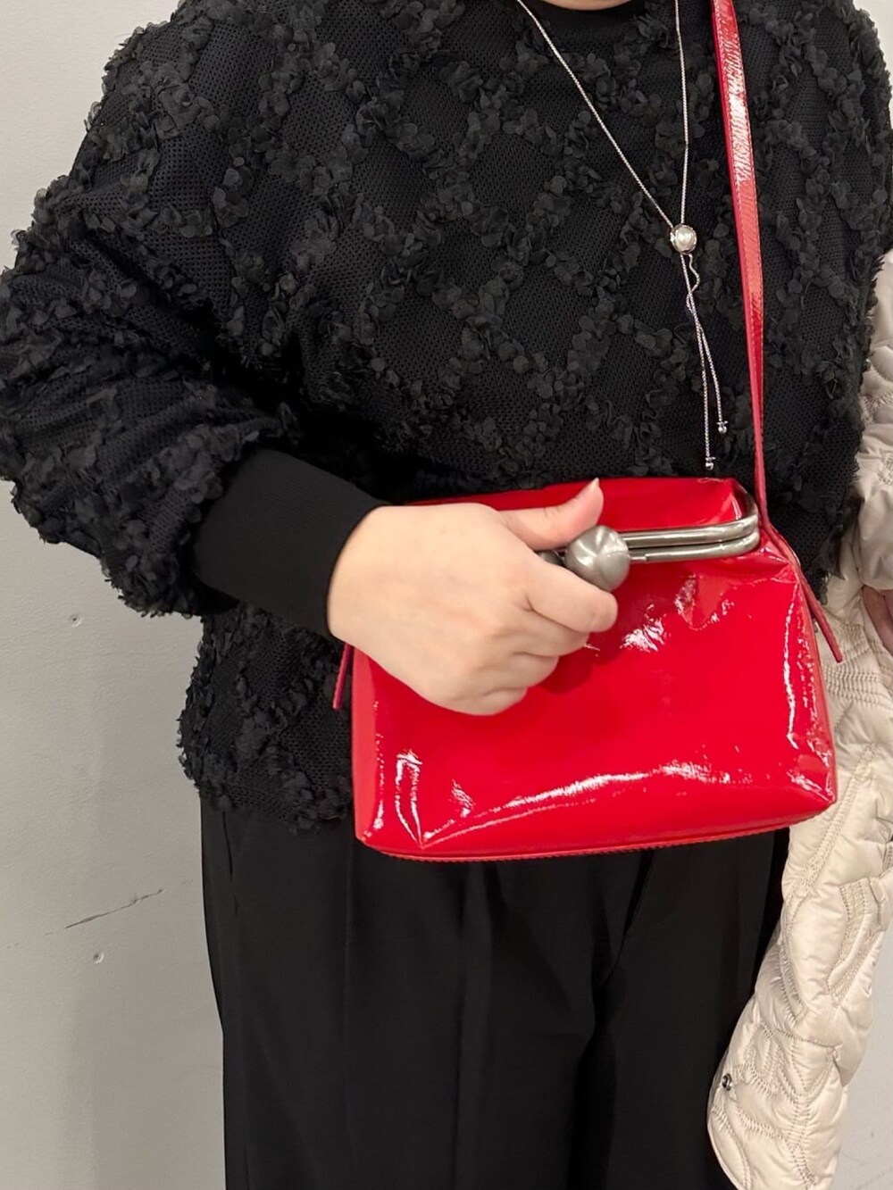 レッド系のショルダーバッグ、ブラック系のTシャツ/カットソーを着用したレディースの冬コーディネートの4枚目の写真