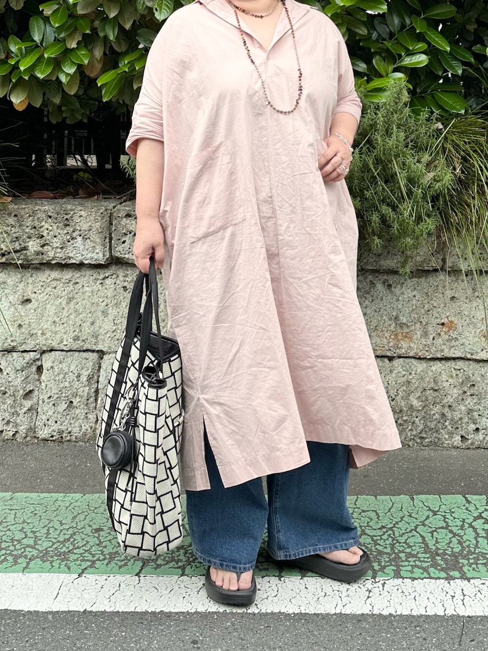 ブラック系のチャームを着用したレディースの夏コーディネートの2枚目の写真