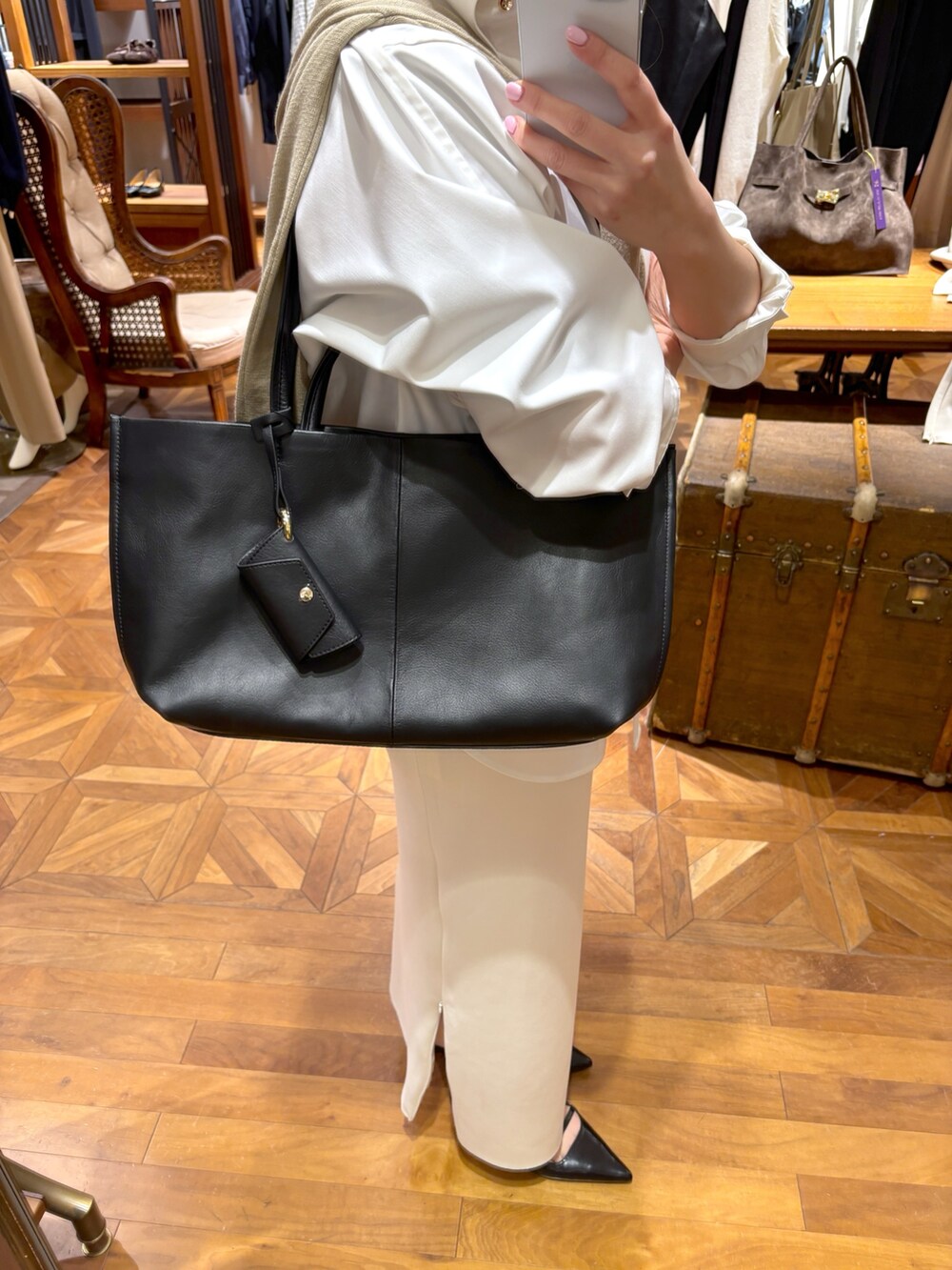 ホワイト系のシャツ/ブラウス、ホワイト系のスカート、ブラック系のトートバッグを着用したレディースの冬コーディネートの6枚目の写真