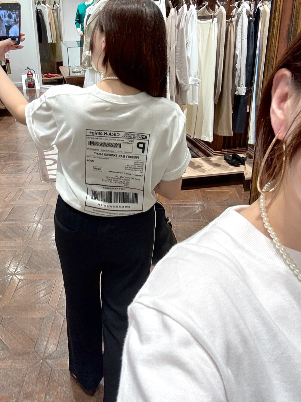 ホワイト系のTシャツ/カットソー、ブラック系のその他パンツ、ブラック系のボストンバッグを着用したレディースの春コーディネートの3枚目の写真