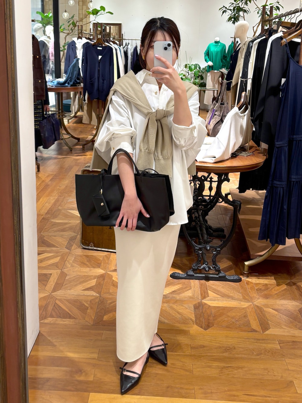ホワイト系のシャツ/ブラウス、ホワイト系のスカート、ブラック系のトートバッグを着用したレディースの冬コーディネートの3枚目の写真