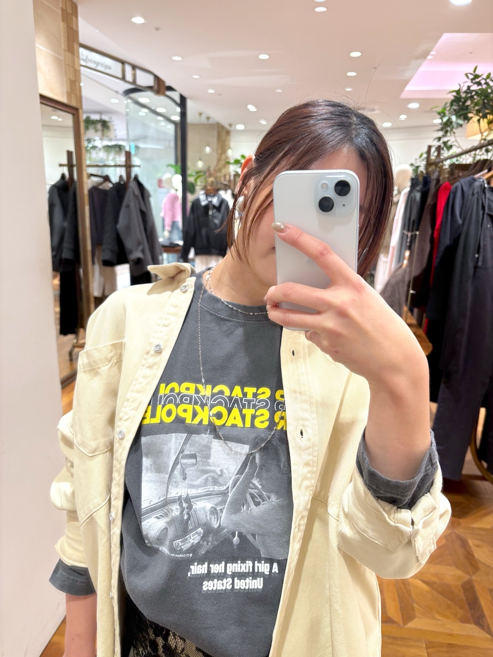 イエロー系のシャツ/ブラウス、イエロー系のデニムパンツ、ブラック系のTシャツ/カットソーを着用したレディースの冬コーディネートの2枚目の写真