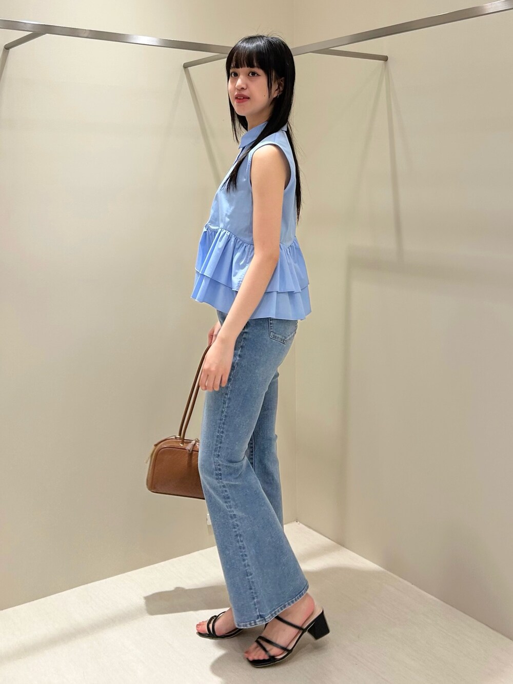 ブルー系のシャツ/ブラウス、ブルー系のデニムパンツ、ブラウン系のボストンバッグを着用したレディースの夏コーディネートの3枚目の写真