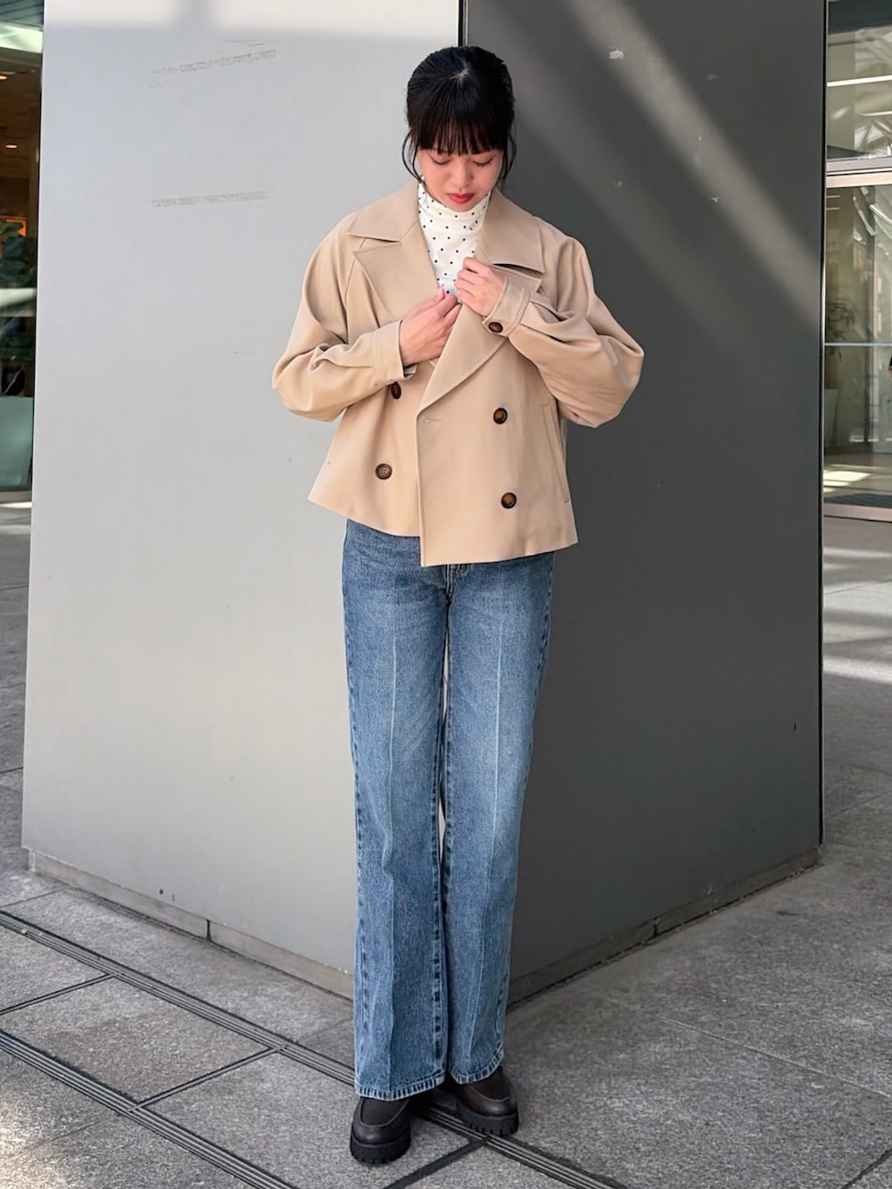 ベージュ系のトレンチコート、ブルー系のその他パンツ、ホワイト系のTシャツ/カットソーを着用したレディースの秋コーディネートの3枚目の写真