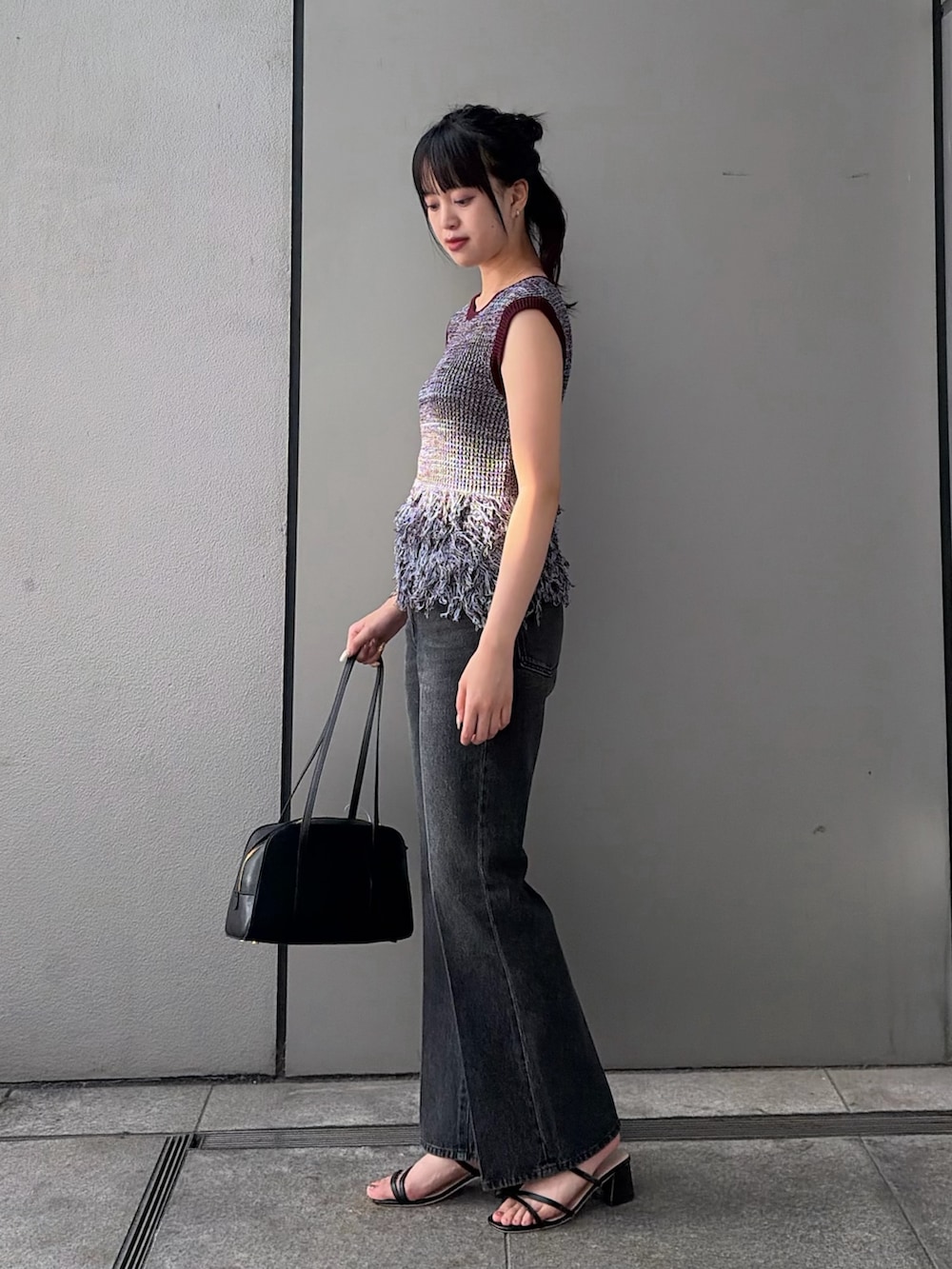 ブラウン系のニット/セーター、ブラック系のその他パンツ、ブラック系のボストンバッグを着用したレディースの夏コーディネートの4枚目の写真