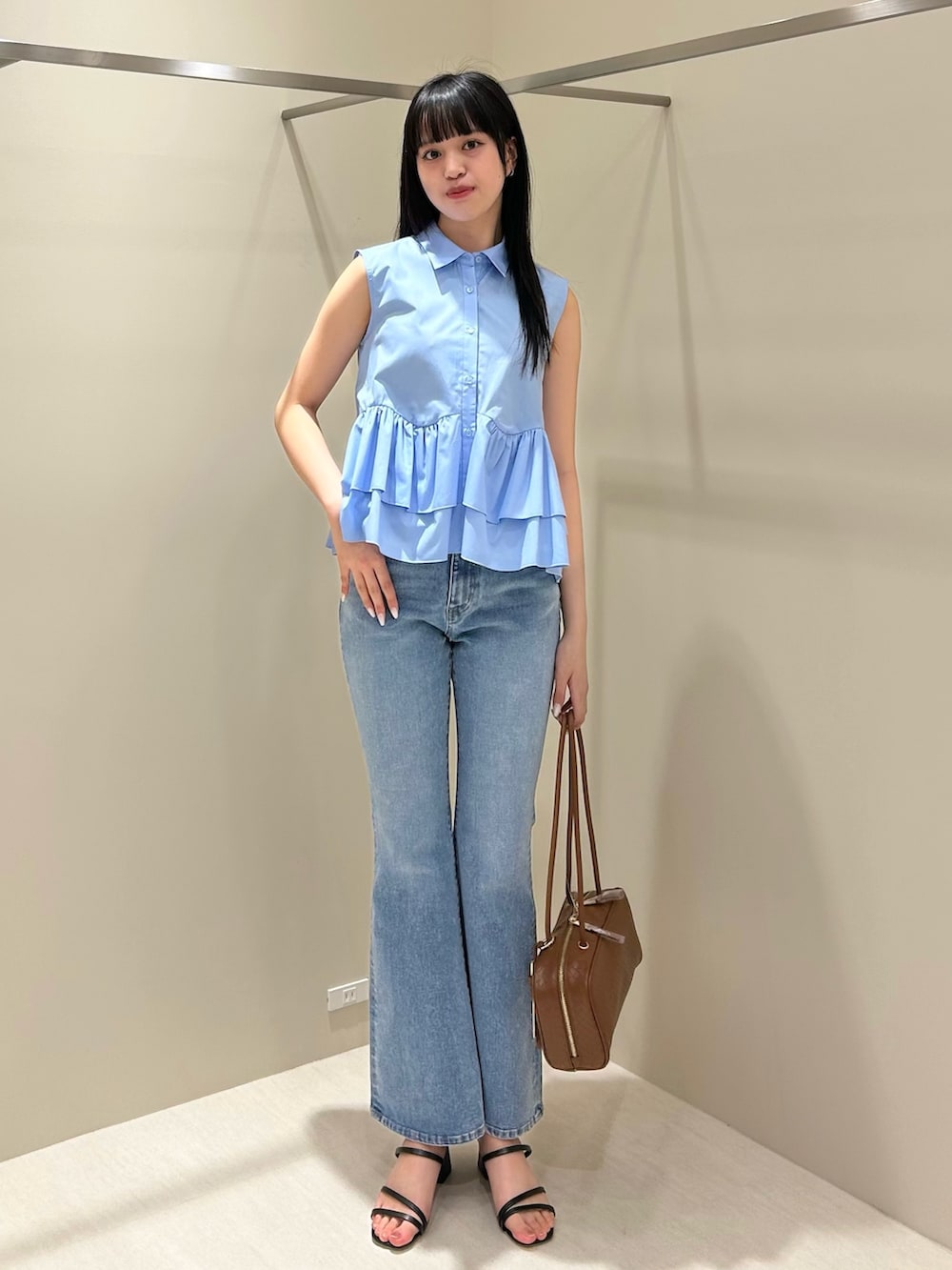 ブルー系のシャツ/ブラウス、ブルー系のデニムパンツ、ブラウン系のボストンバッグを着用したレディースの夏コーディネートの2枚目の写真