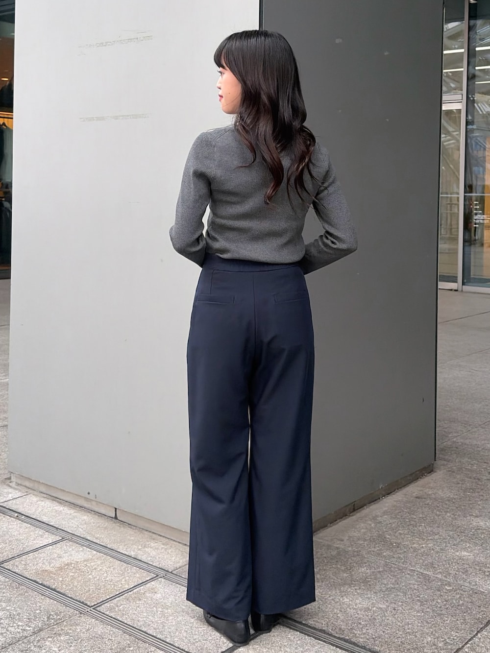 グレー系のニット/セーター、ブルー系のその他パンツ、ブラウン系のボストンバッグを着用したレディースの秋コーディネートの4枚目の写真