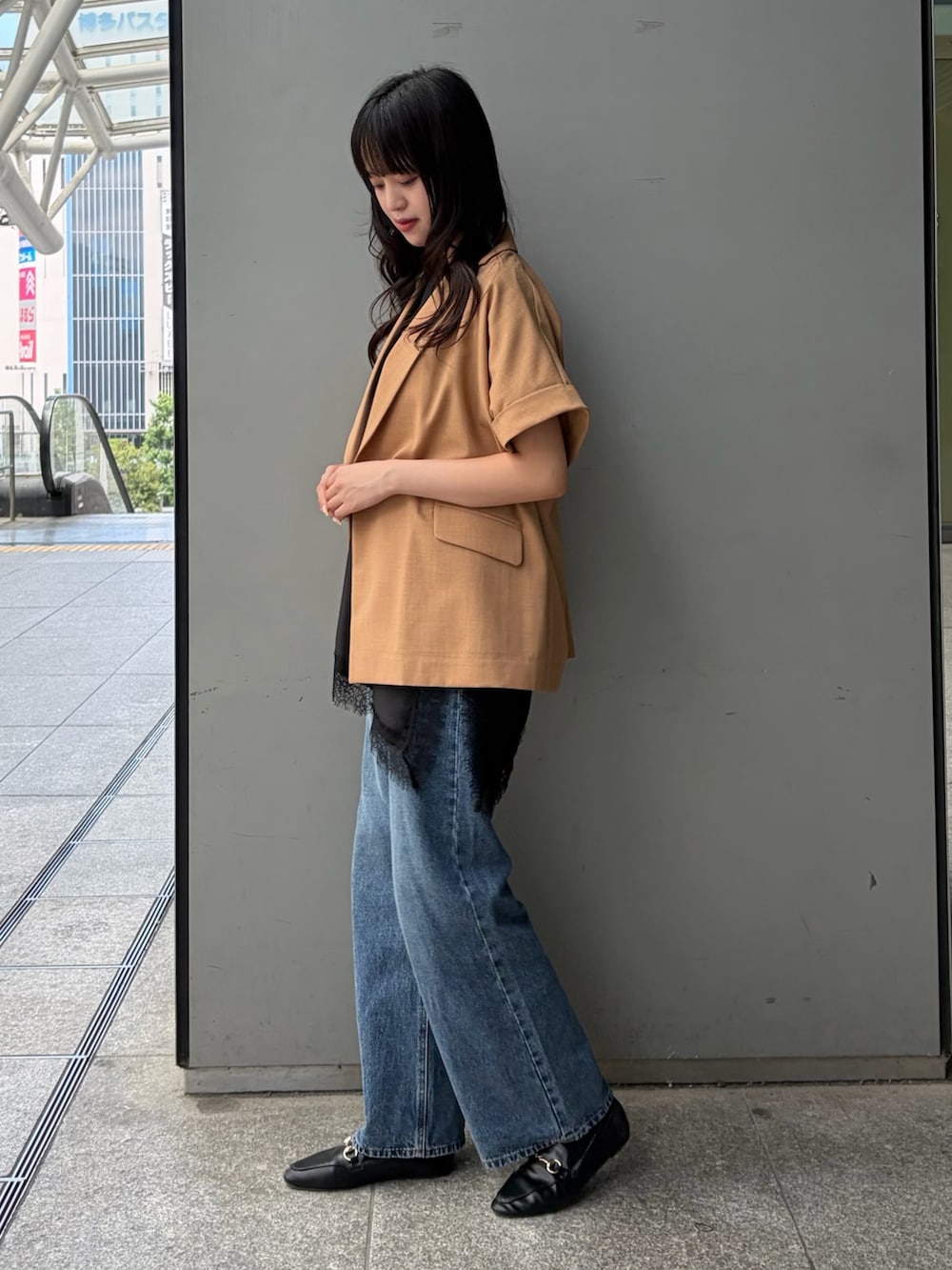 イエロー系のテーラードジャケット、ブラック系のTシャツ/カットソー、ブルー系のデニムパンツを着用したレディースの夏コーディネートの3枚目の写真