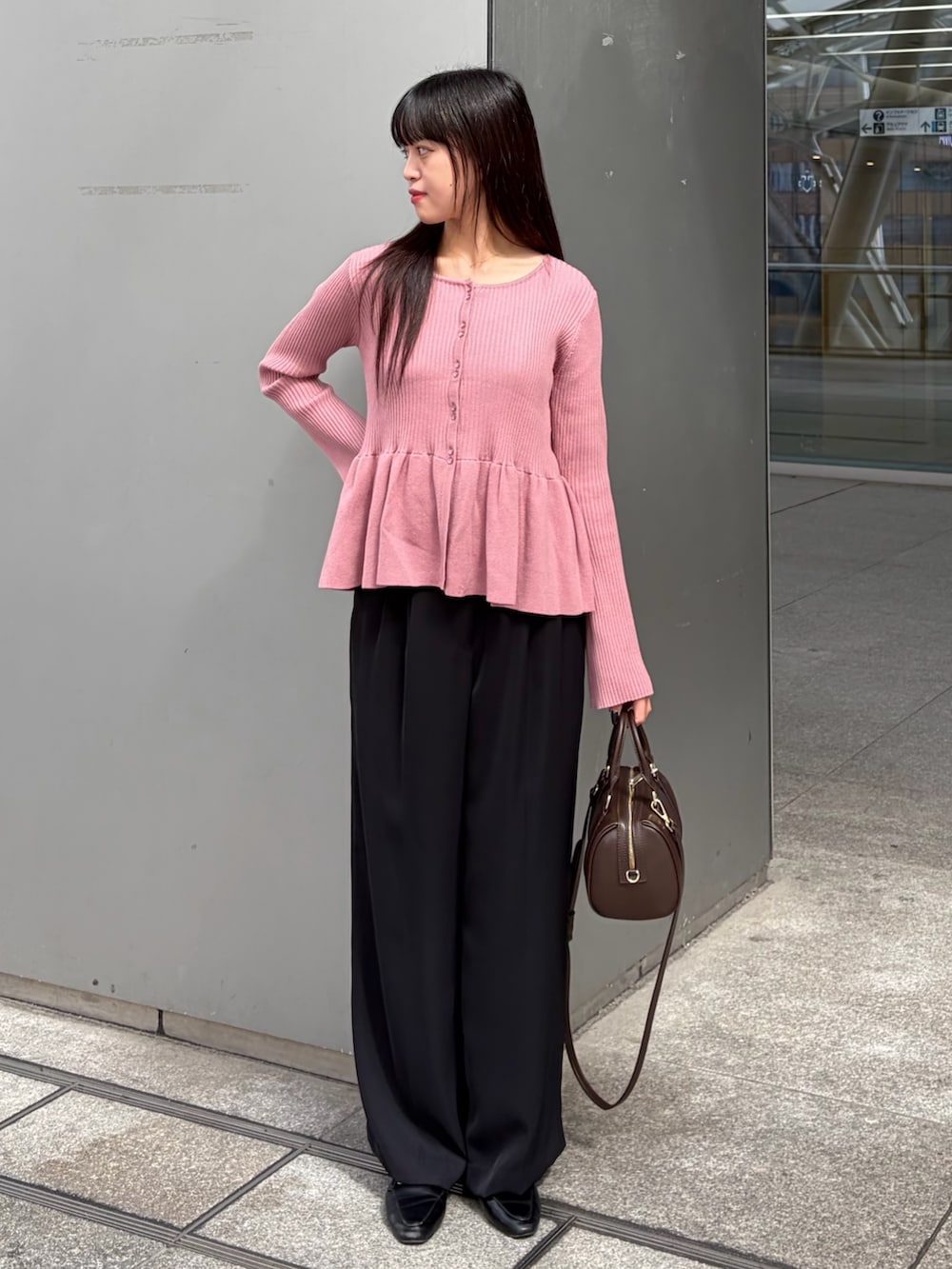 ピンク系のカーディガン/ボレロ、ブラック系のその他パンツ、ブラウン系のボストンバッグを着用したレディースの秋コーディネートの2枚目の写真