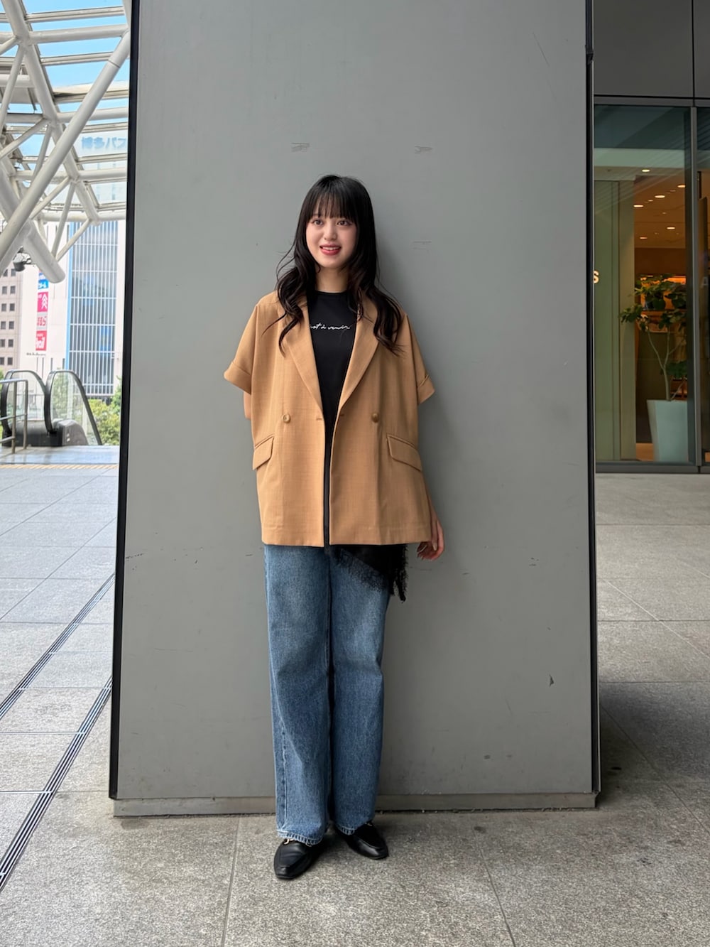 イエロー系のテーラードジャケット、ブラック系のTシャツ/カットソー、ブルー系のデニムパンツを着用したレディースの夏コーディネートの4枚目の写真