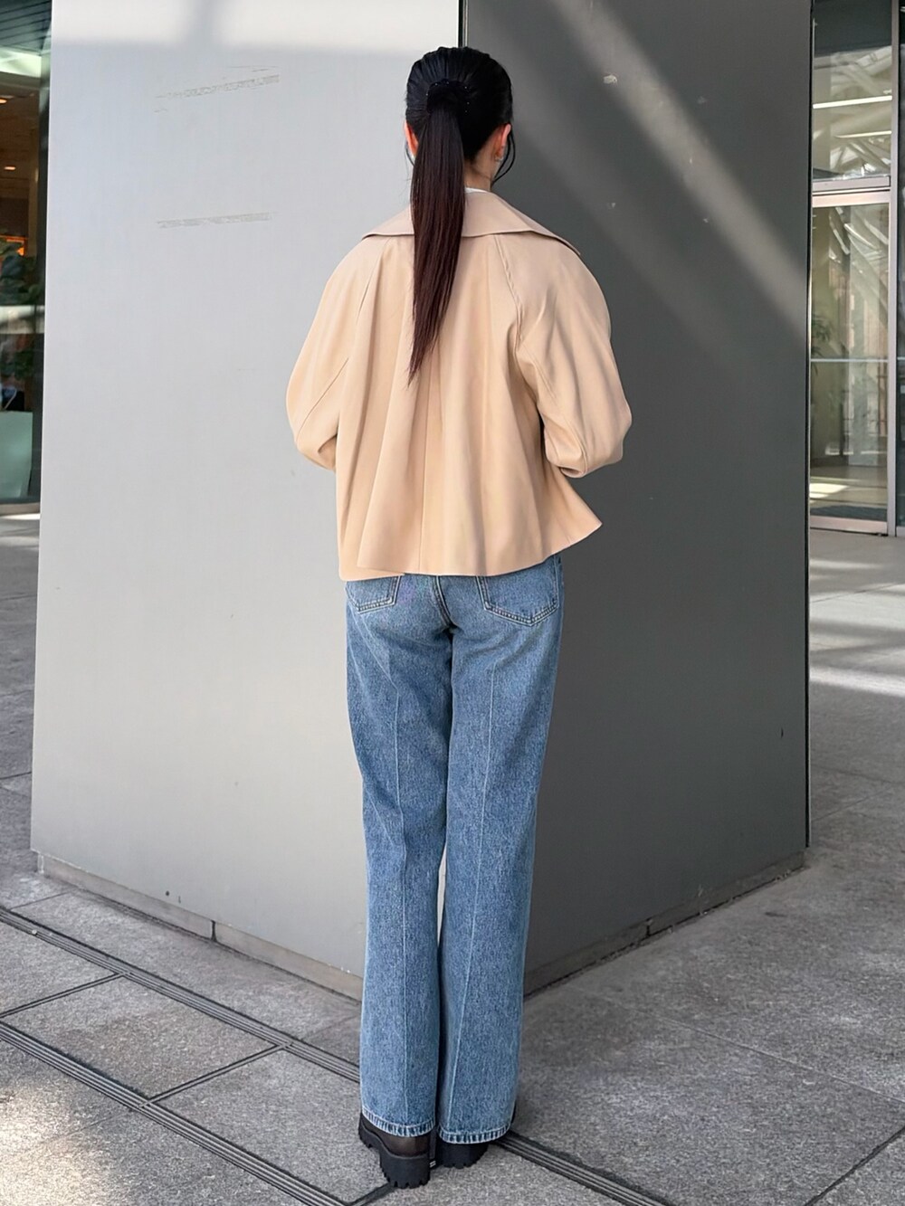 ベージュ系のトレンチコート、ブルー系のその他パンツ、ホワイト系のTシャツ/カットソーを着用したレディースの秋コーディネートの5枚目の写真