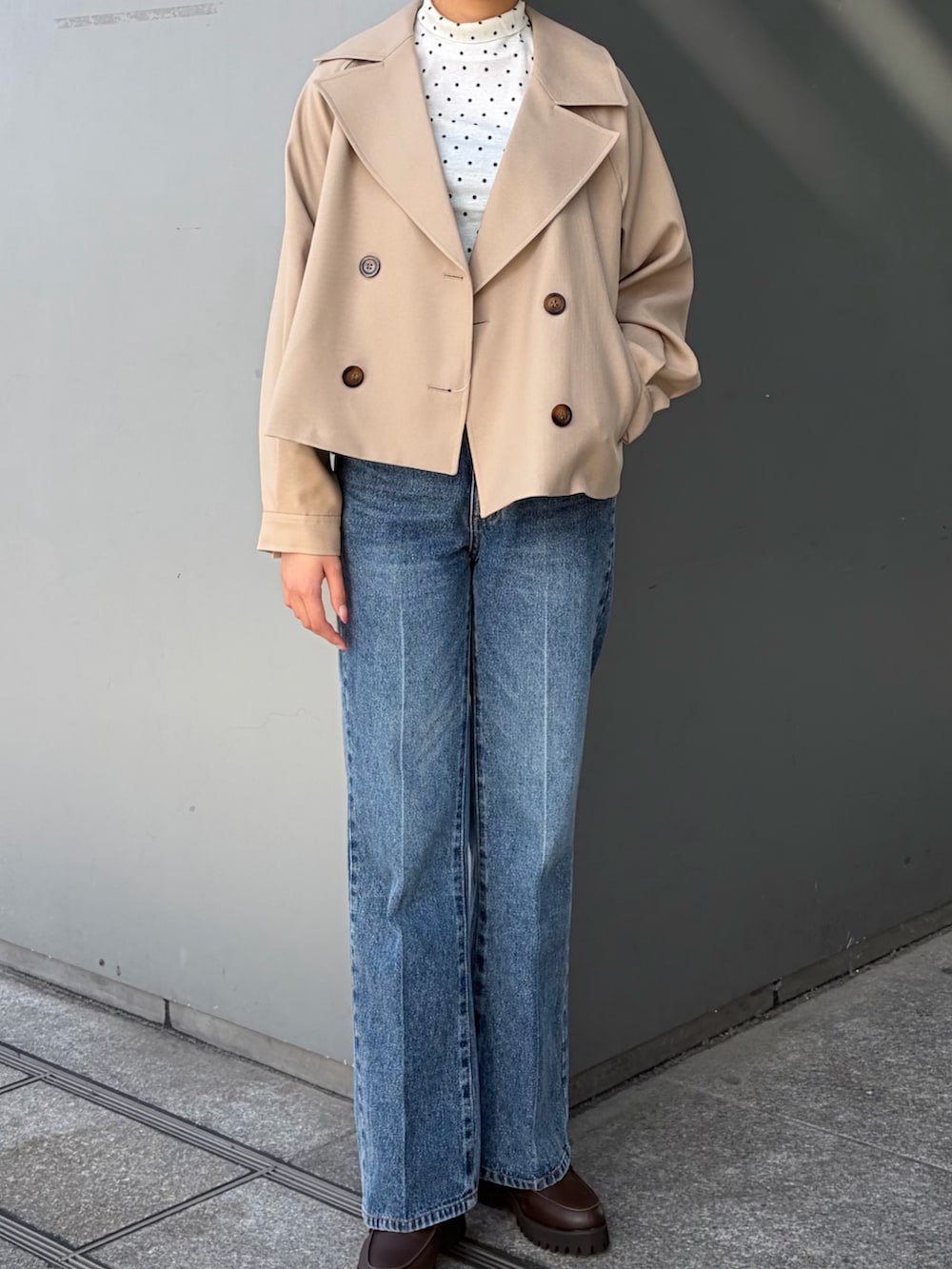 ベージュ系のトレンチコート、ブルー系のその他パンツ、ホワイト系のTシャツ/カットソーを着用したレディースの秋コーディネートの2枚目の写真