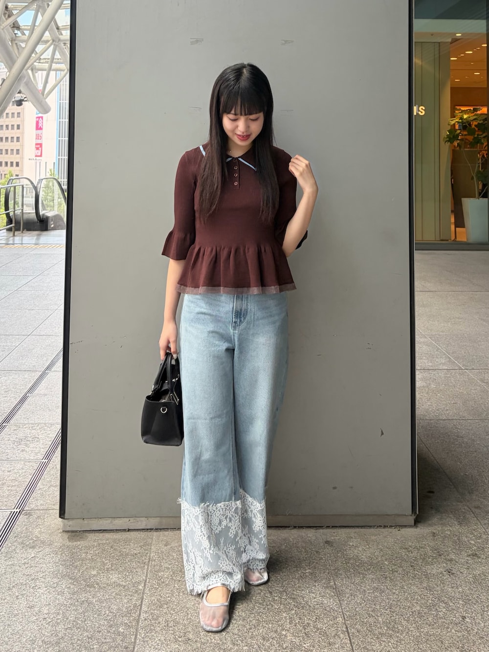 ブラウン系のニット/セーター、グリーン系のトートバッグ、ブルー系のデニムパンツを着用したレディースの夏コーディネートの2枚目の写真