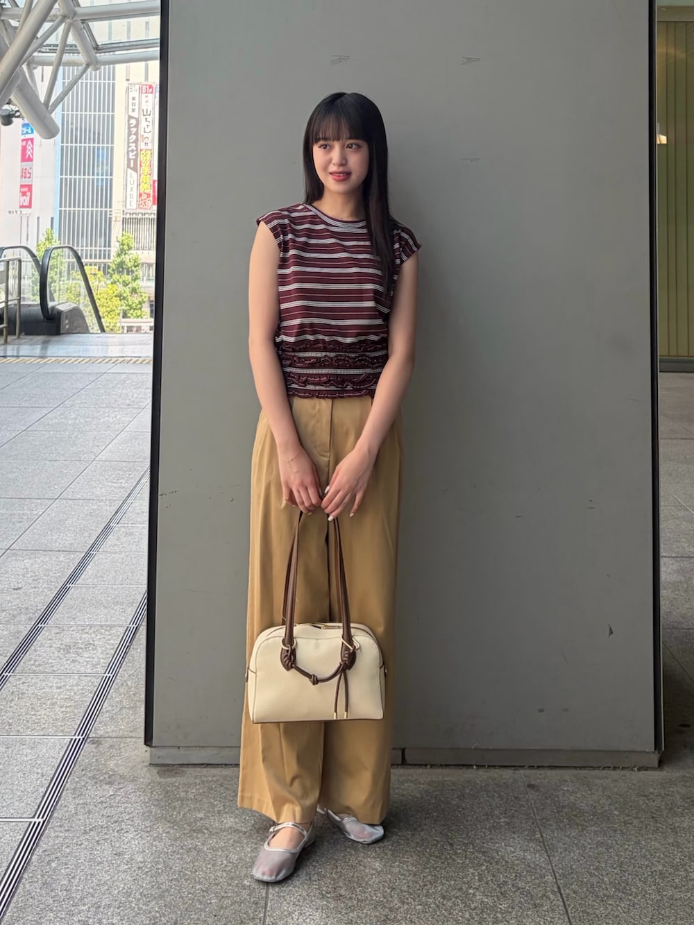 ブラウン系のTシャツ/カットソー、ベージュ系のその他パンツ、ホワイト系のボストンバッグを着用したレディースの夏コーディネートの2枚目の写真