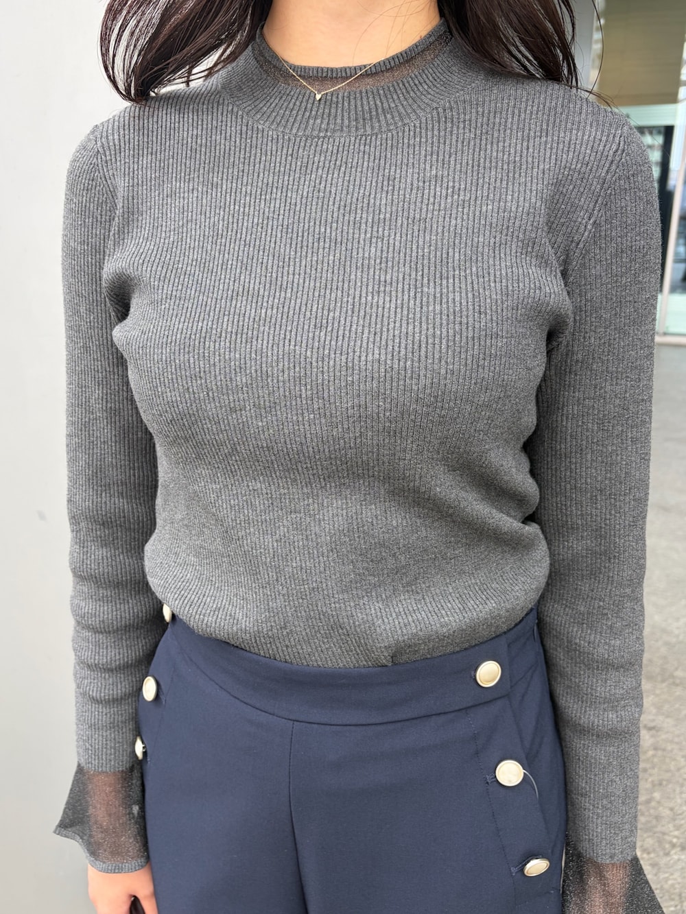 グレー系のニット/セーター、ブルー系のその他パンツ、ブラウン系のボストンバッグを着用したレディースの秋コーディネートの6枚目の写真